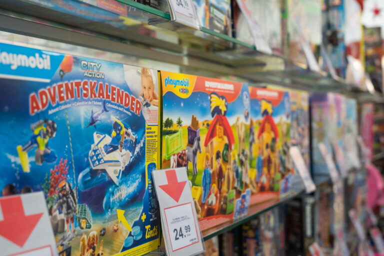 Regal mit Playmobil-Adventskalendern in bunten Verpackungen, Preisetiketten vorne sichtbar